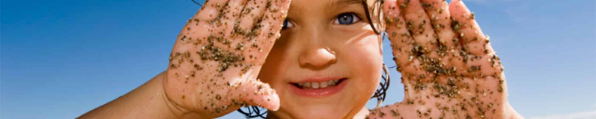 Child smiling through hands Child smiling through hands